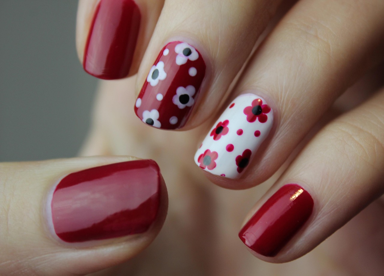 Red floral nail art on a manicured hand